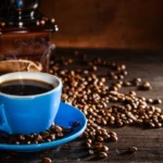 cup-coffee-with-coffee-beans-grinder-background_1112-430