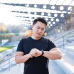 athlete-looks-watch-asian-man-disappointed-with-his-result-running-time-calories-burned-after-training-running_321831-9375