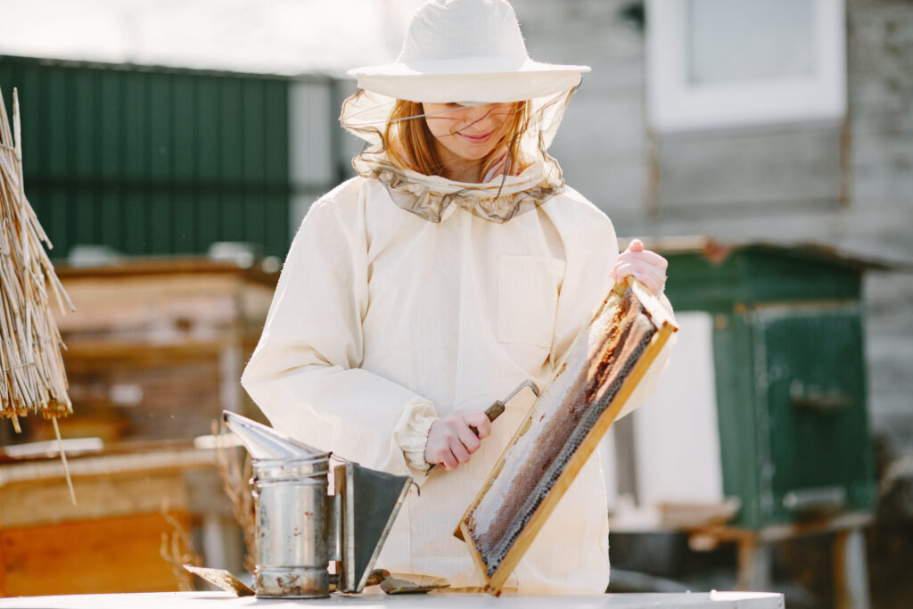 young man holding honeycomb from beekeeper rustic village warm golden light